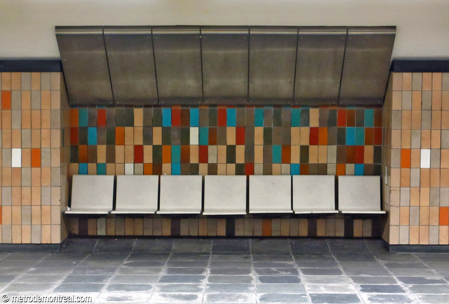 The tiles behind the platform benches are more variegated than those on the rest of the walls.