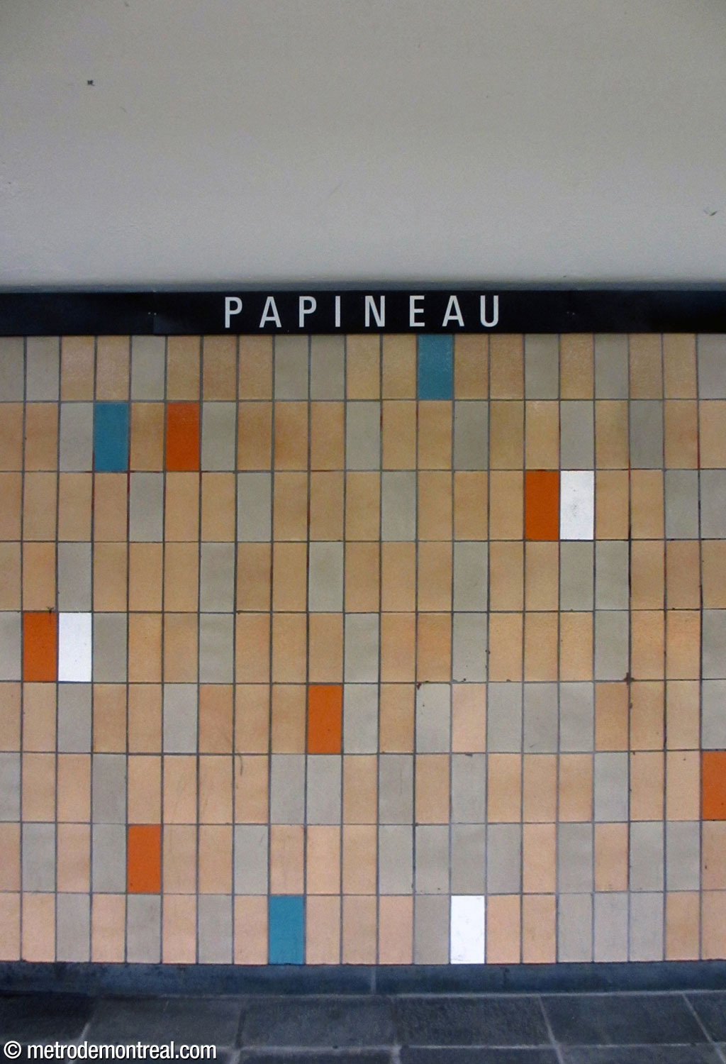 The tiling pattern used in most of the station: tan and light grey with blue, red-orange, and white accents.