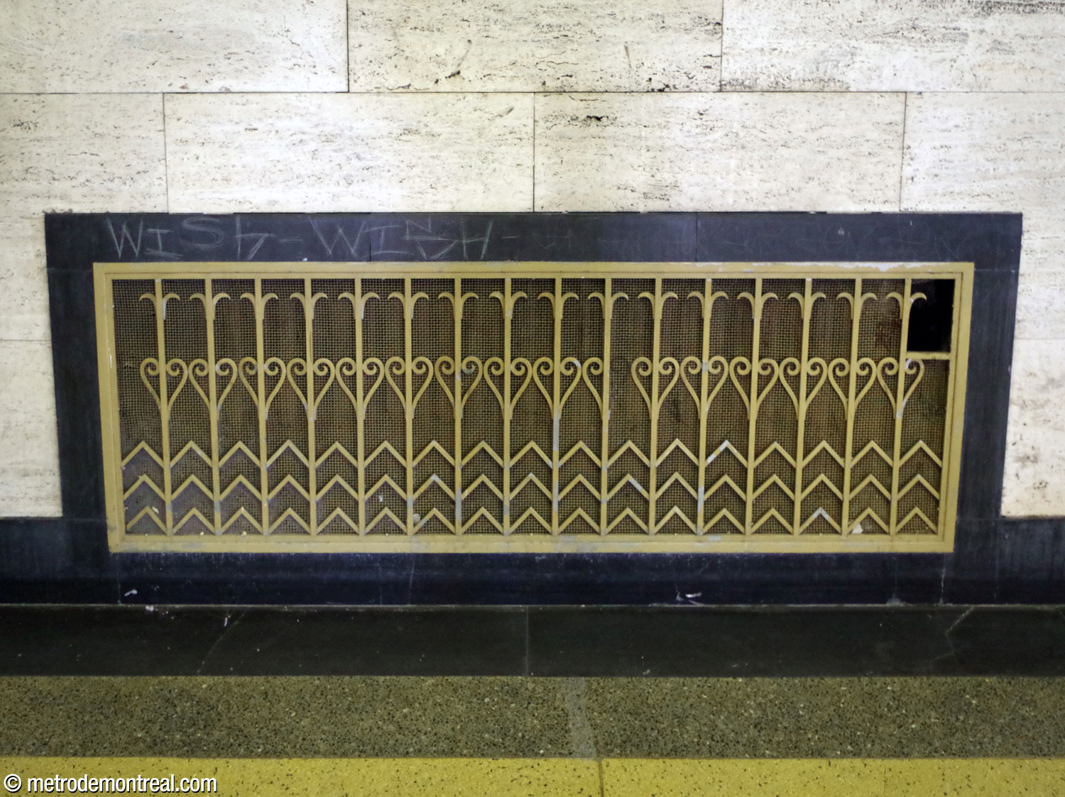 Une grille en laiton au mur sud de l'accès au métro présente des motifs décoratifs de style Art déco.