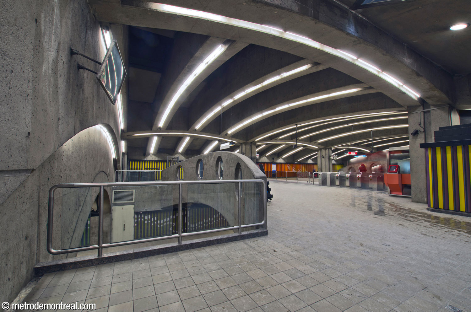 La billetterie vue à partir du pied des escaliers vers la sortie. Au centre, le parapet du côté ouest de la mezzanine donne sur les quais; la ligne de perception est au centre droit.