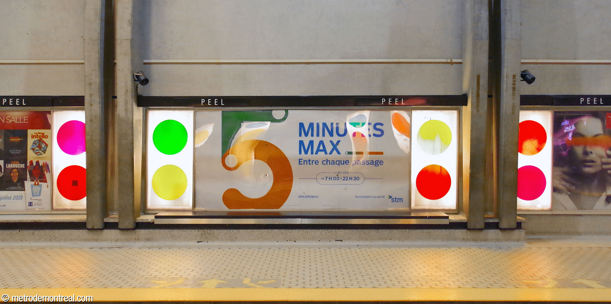 D'insolites panneaux rétroéclairés arborant des cercles colorés encadrent les affiches publicitaires le long des quais.