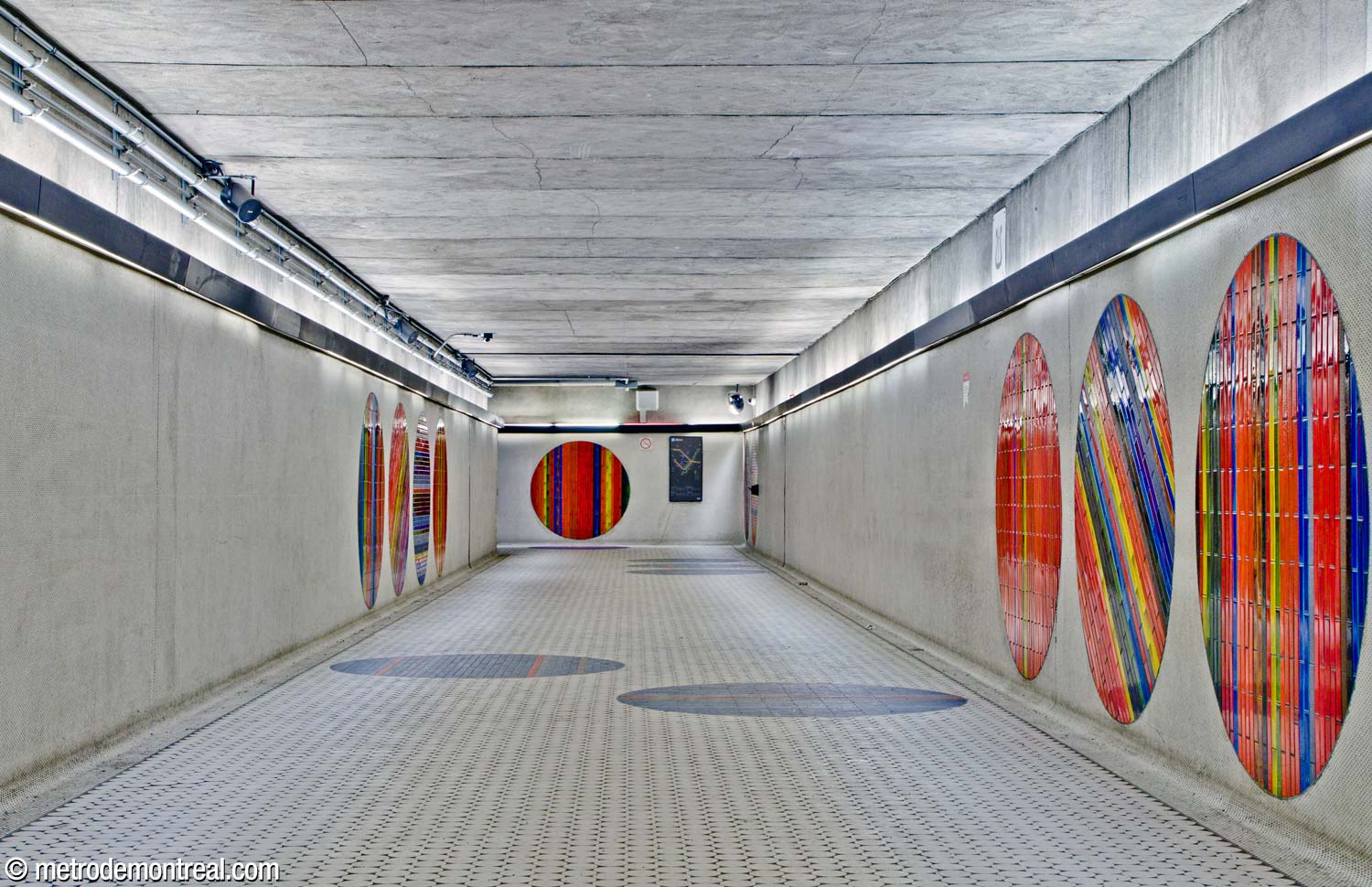 Treize des cercles de Jean-Paul Mousseau sont visibles dans le corridor donnant accès à la sortie Metcalfe; vue vers l'ouest, en direction de la station.