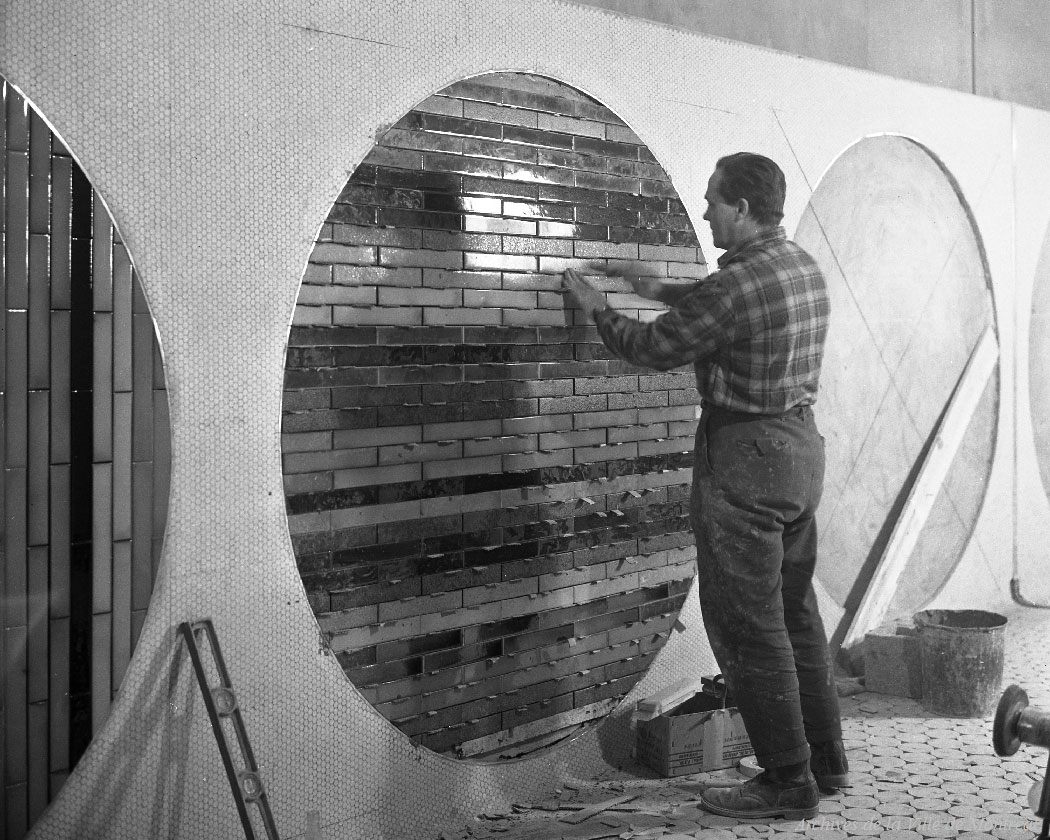 Un ouvrier installe l’un des cercles carrelés