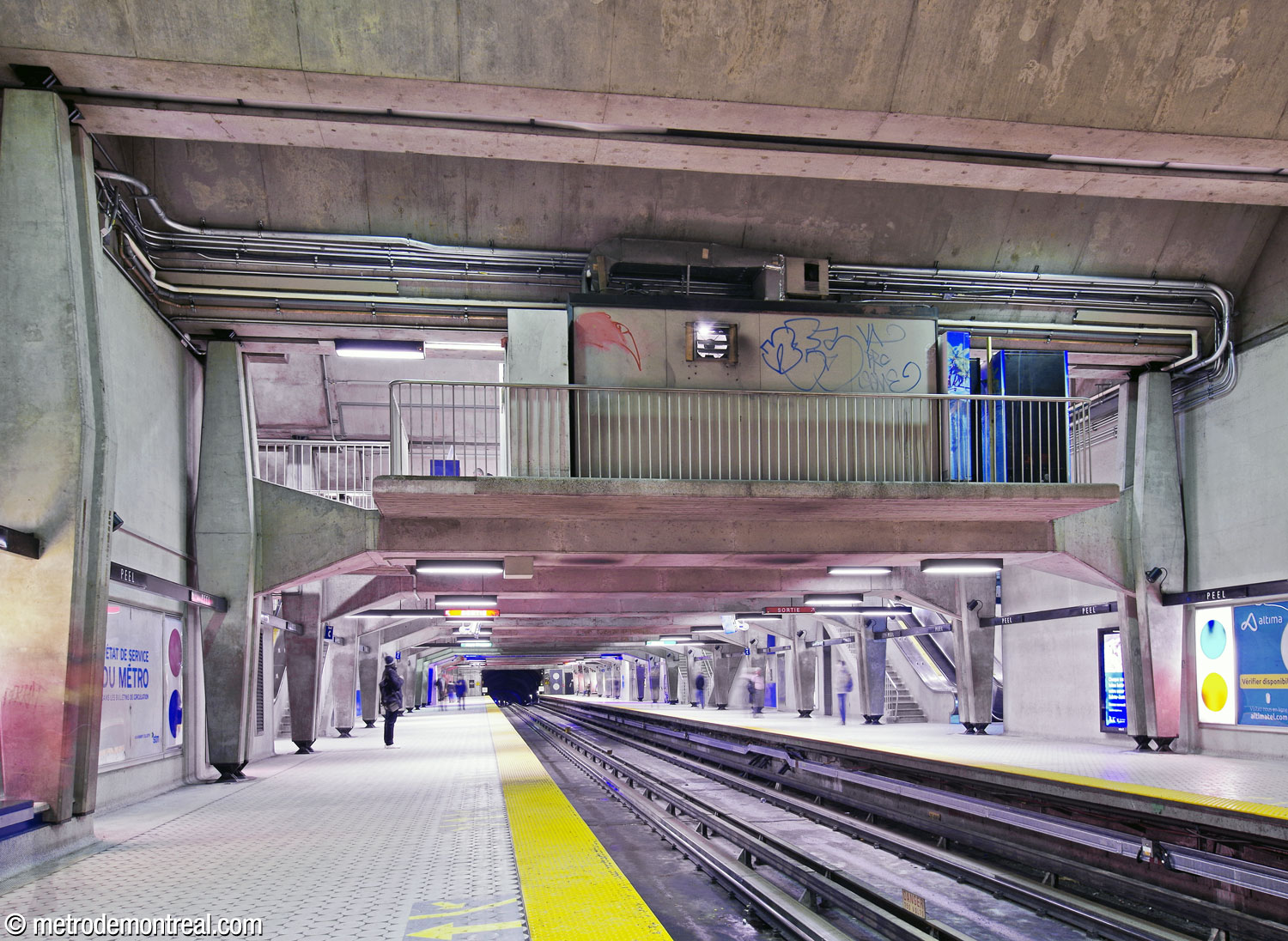 La mezzanine de la station flotte dans le volume rectangulaire de la station, appuyée par des poutres en béton accrochées aux piliers en forme de losange de part et d’autre.
