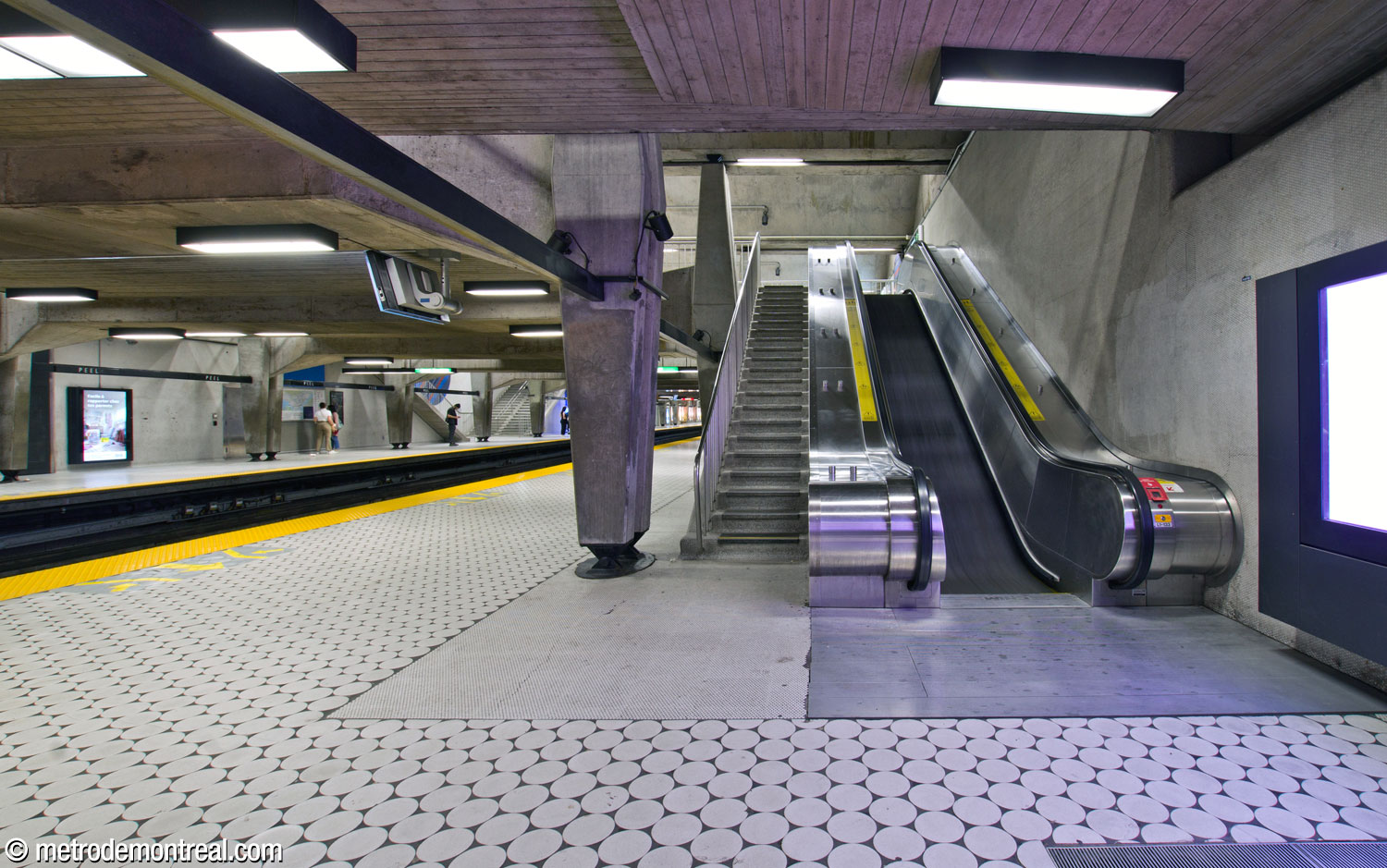 Sur chaque quai, les deux volées extérieures d’escalier jumellent un escalier fixe et un escalier mécanique montant. On le voit ici sur le quai Angrignon.