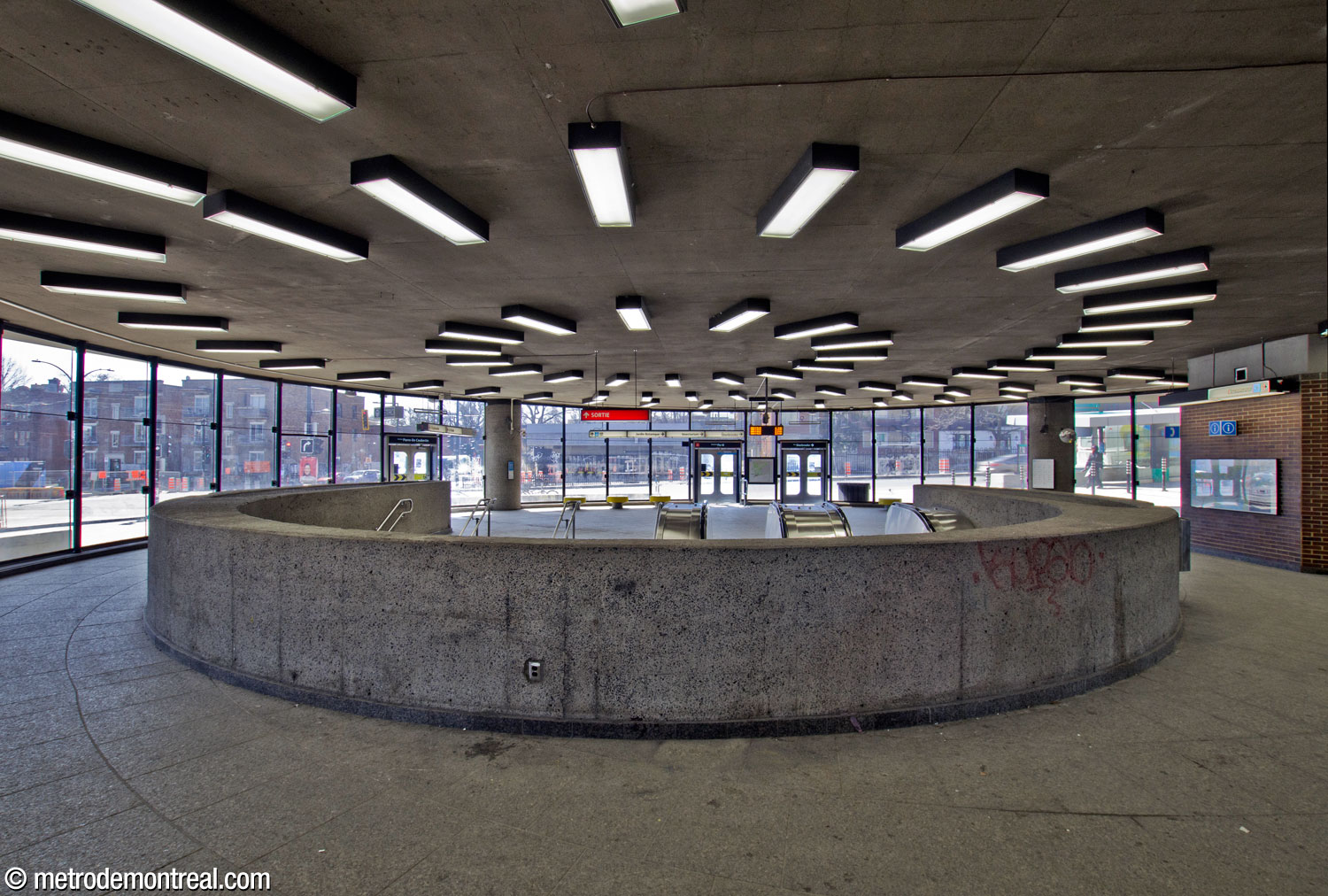 View toward the curved glass façade at the front of the Pie-IX Est access, from behind the round stairwell opening.