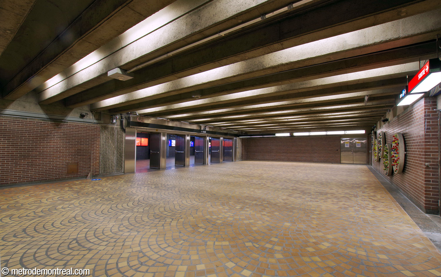 The eastern end of the concourse, leading to the underground city access to the stadium. Marcel Raby’s mural sculpture is at right.