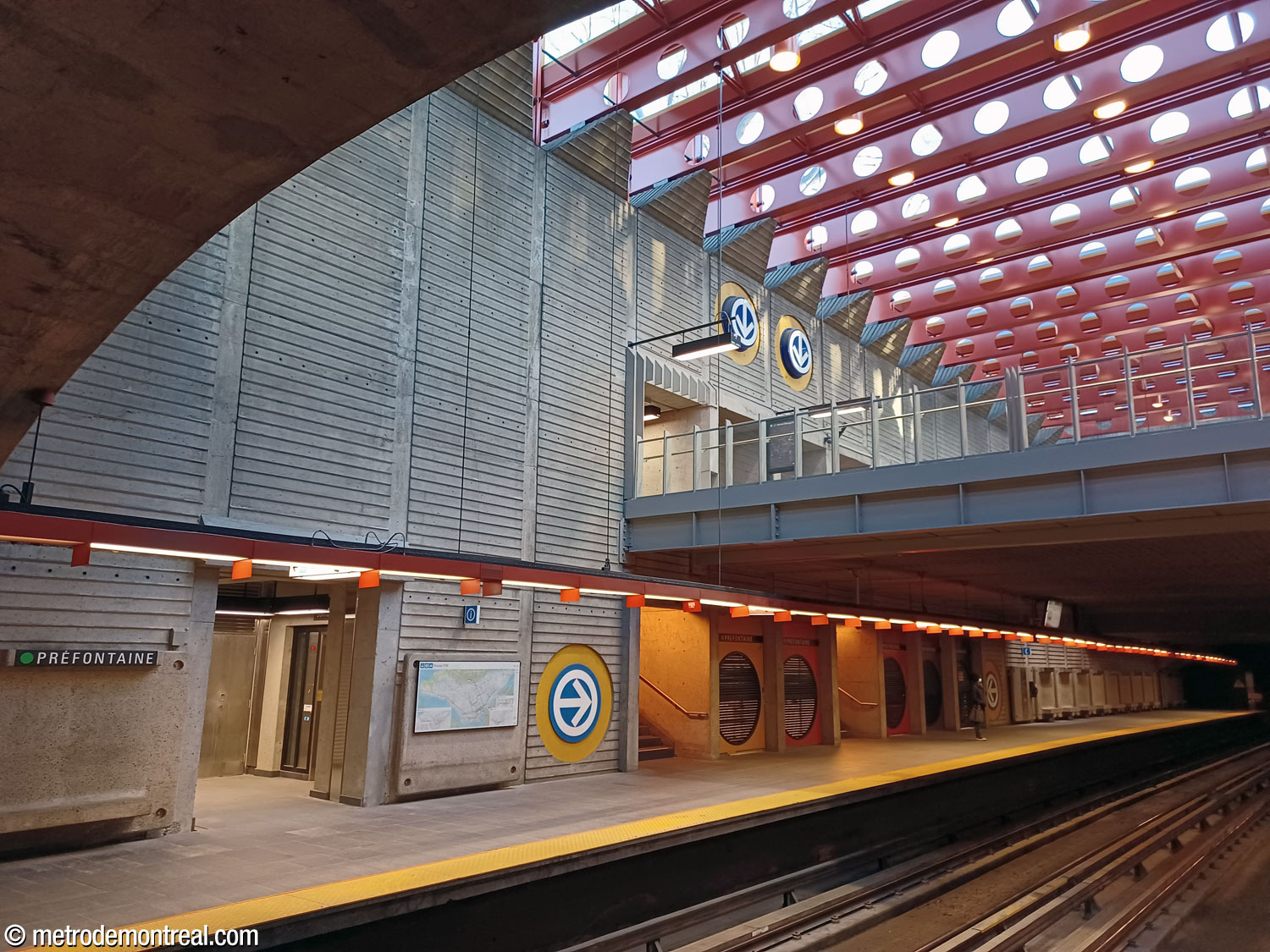 Le vaste vide au-delà du parapet de la mezzanine, qui permet l'infiltration du soleil admis par le toit vitré de l'édicule à travers le grand volume de la station jusqu'aux quais.