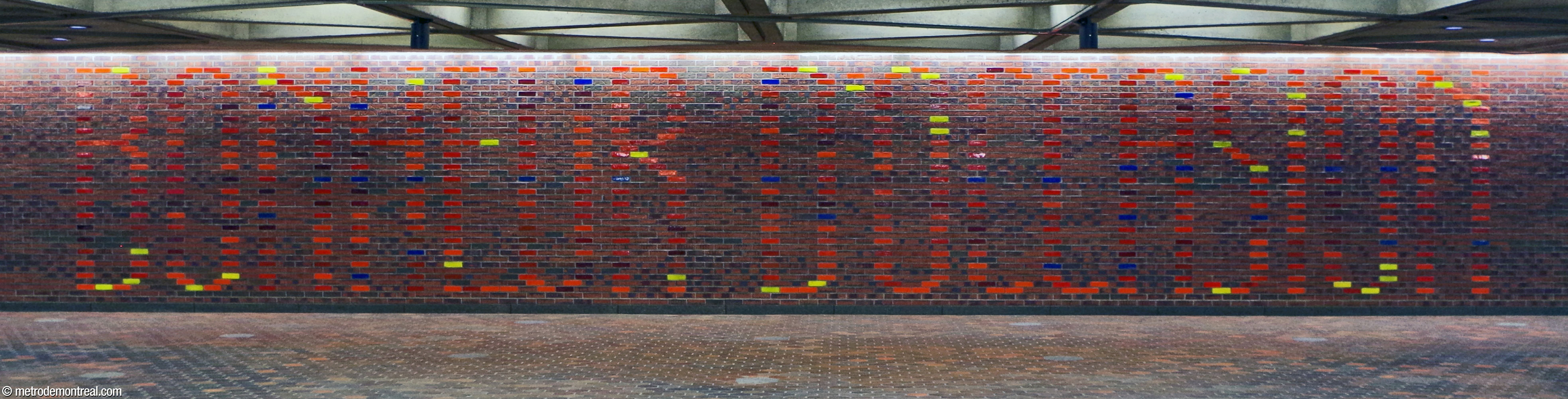 The mural Bonheur d'Occasion by station architect Julien Hébert, in glazed bricks on the western wall of the fare-paid zone.