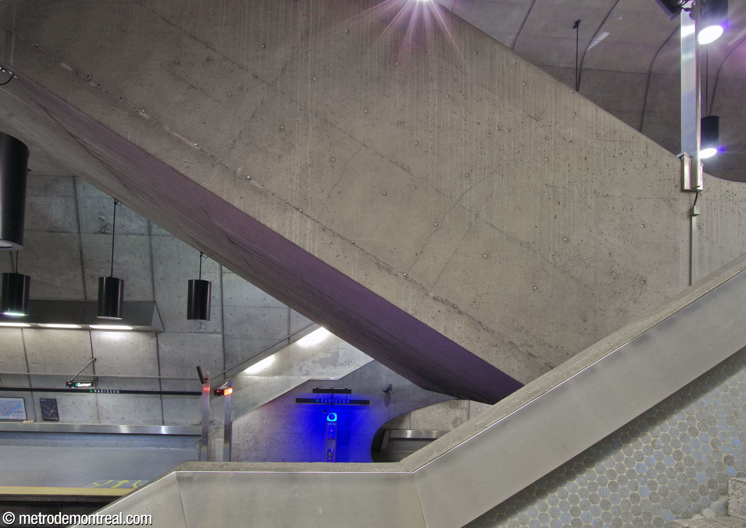 Les lancées opposées de l’escalier depuis le quai et la volée d’escaliers mécaniques au-dessus.