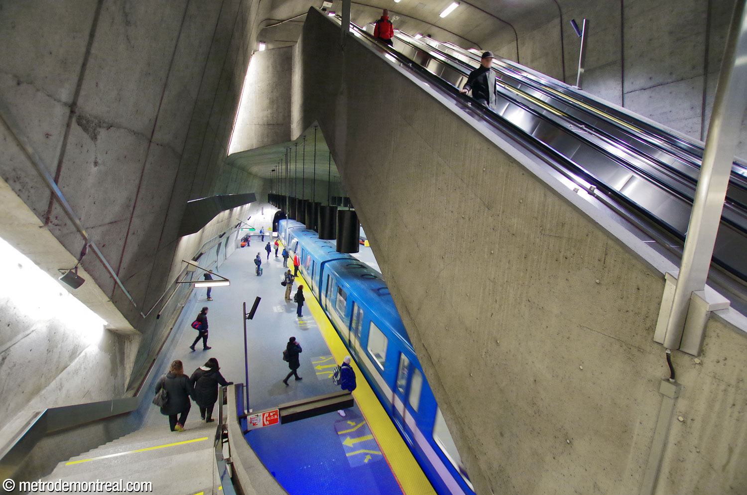 La perspective frappante de la portion est des quais en regardant depuis la passerelle et sous la volée des escaliers mécaniques.