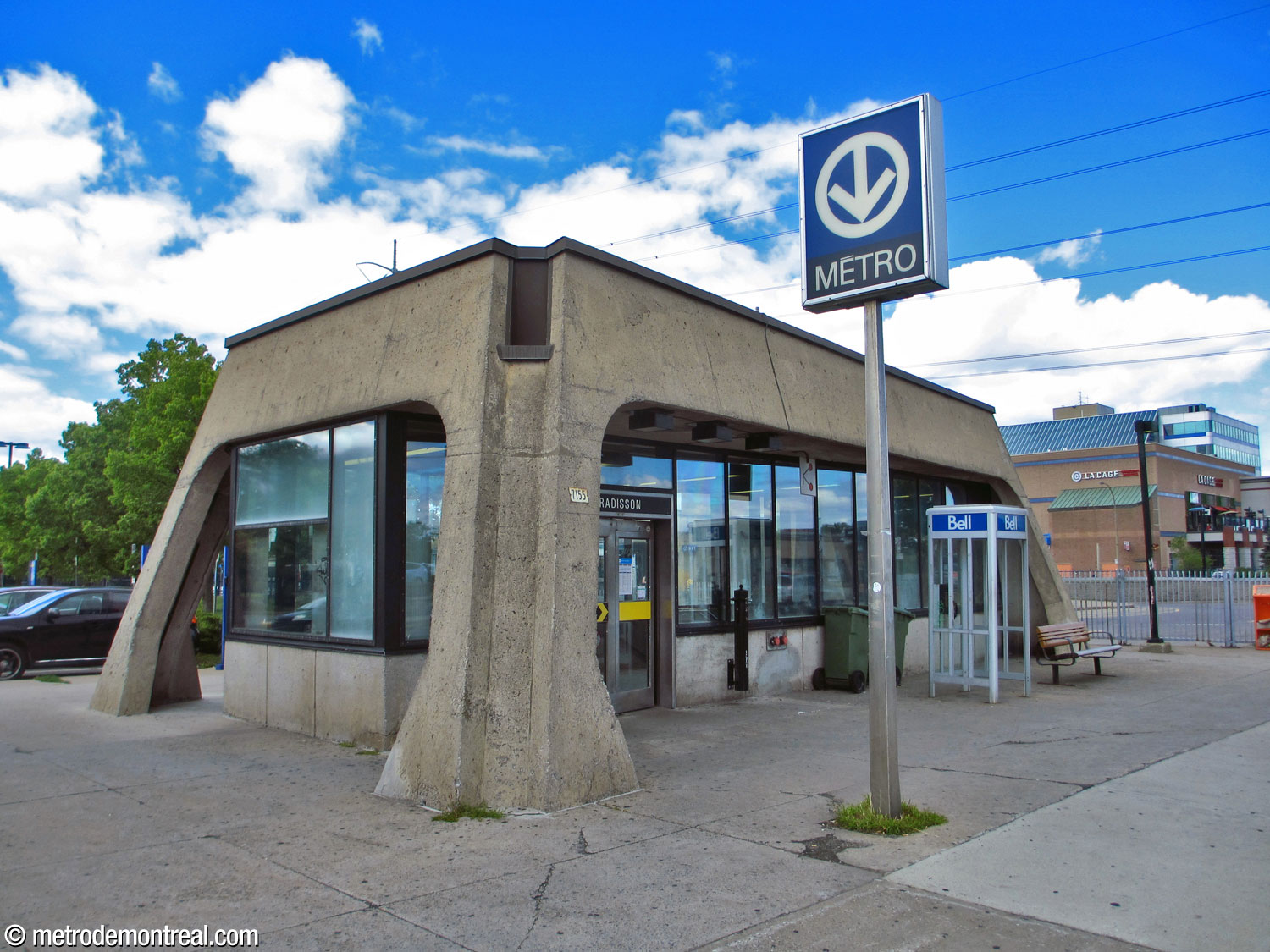 Extérieur de l'édicule Sherbrooke Nord. Ce petit bâtiment consiste d’un toit en béton qui repose sur des colonnes externes obliques, avec des murs-rideaux de verre en dessous.