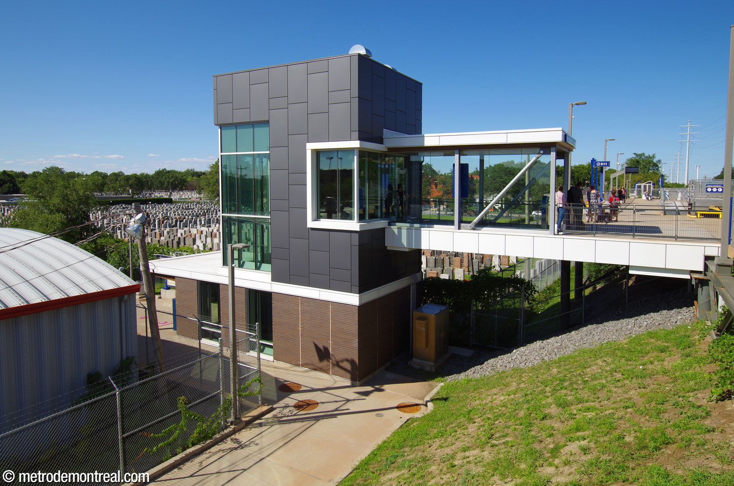 L'édicule de la gare est un bâtiment assez simple, paré de brique brune, de panneaux métalliques gris et de verre. Il abrite un escalier et un ascenseur vers le niveau du quai, qui est construit sur un talus; une passerelle permet de rejoindre le quai.