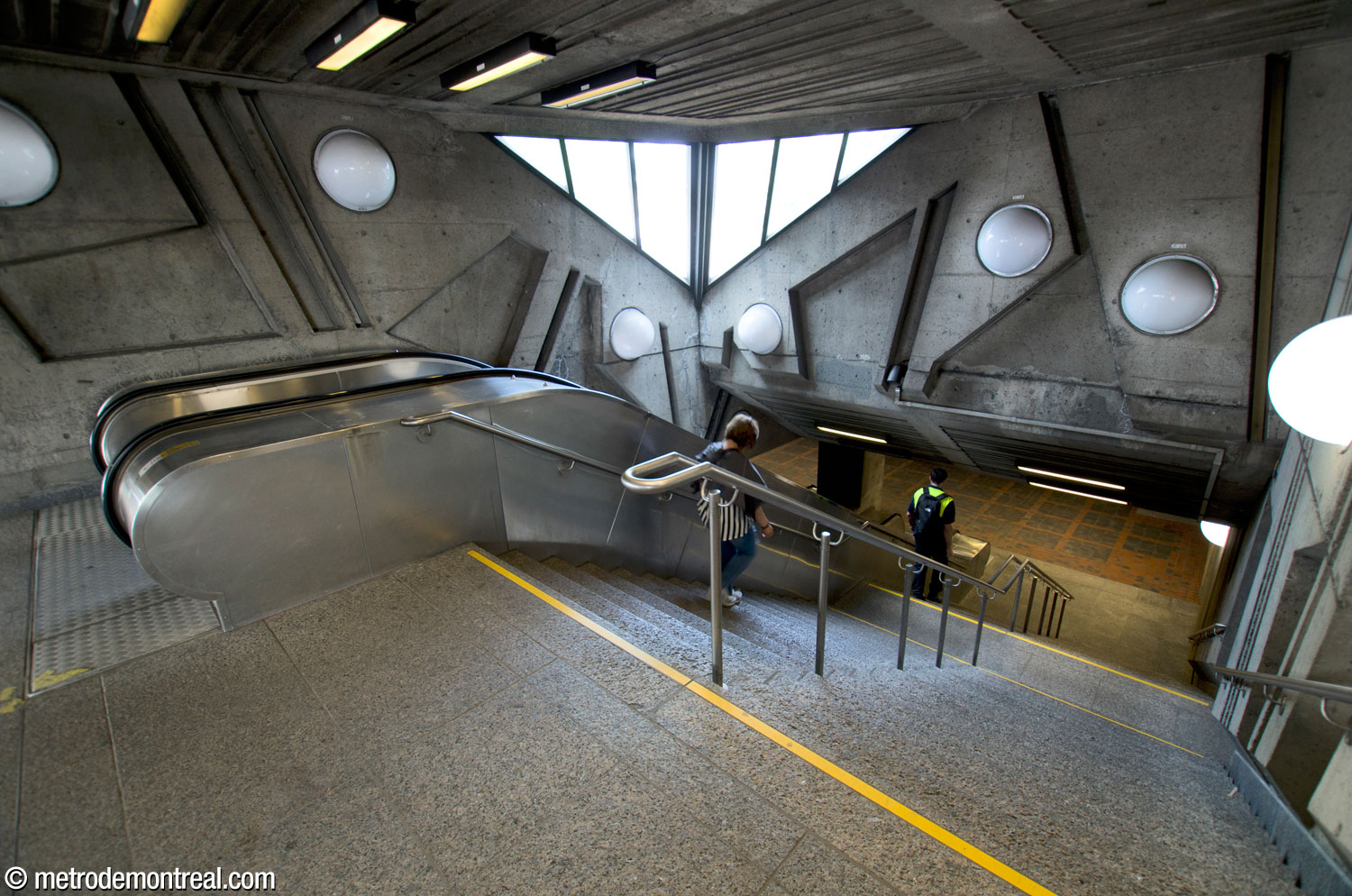 La tête des escaliers, au rez-de-chaussée. On aperçoit le palier au pied de cette première volée. La fenêtre triangulaire est aménagée vis-à-vis d’une autre qui illumine le puits de lumière.