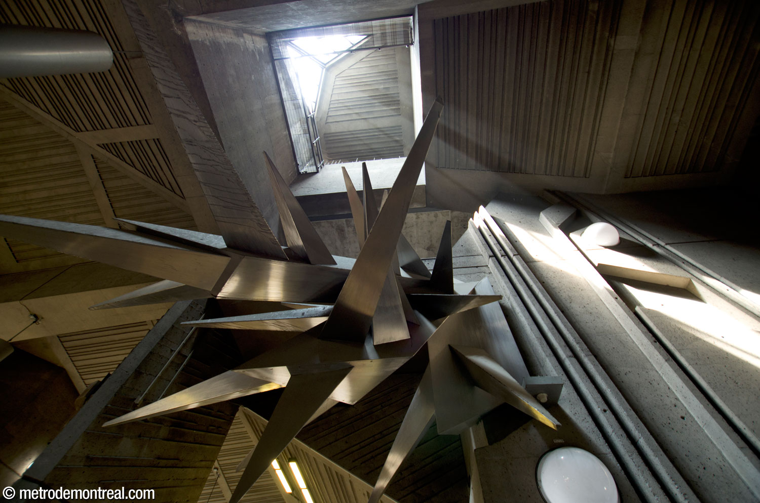 La sculpture Calcite de Maurice Lemieux vue en contre-plongée. En haut, le puits de lumière fait jaillir dans le grand volume la lumière naturelle admise par des fenêtres dans l’édicule.