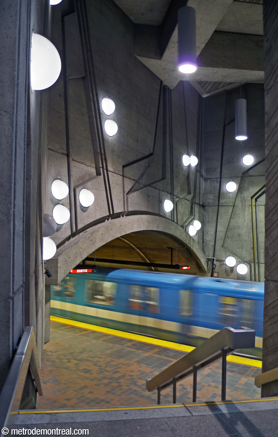 Vue depuis l'escalier donnant accès au quai Côte-Vertu. Le mur tympan du côté sud du grand volume, avec ses formes obliques cannelées parsemées de lampes hémisphériques, surplombe la voûte de la nef.