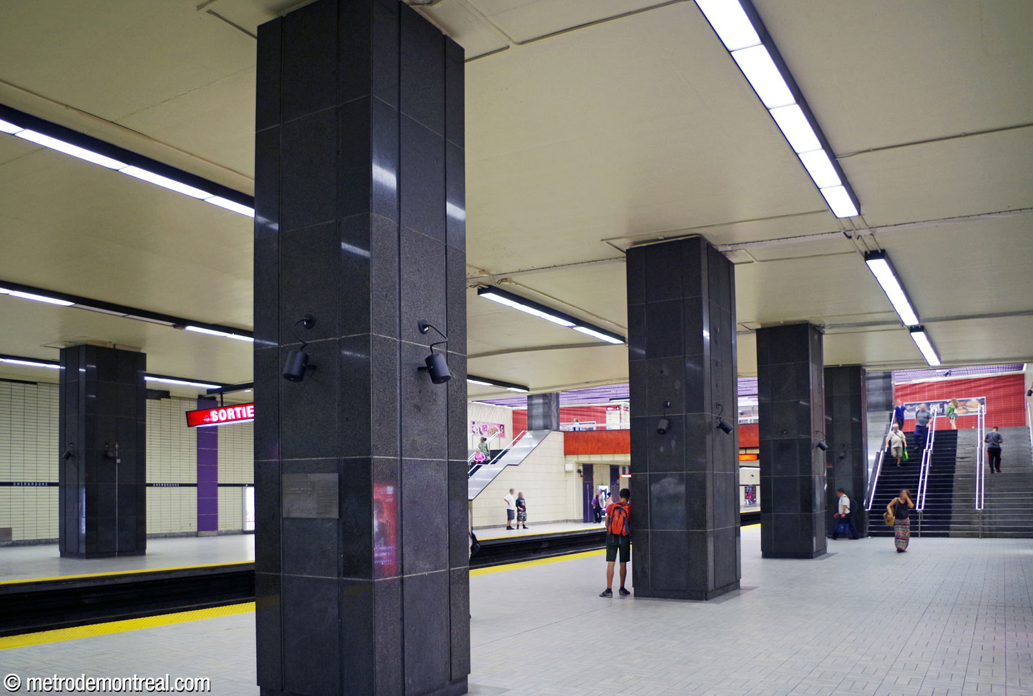 The side aisle of the Côte-Vertu platform, separated from the platform edge by a colonnade, leads to the stairs up to the mezzanine.