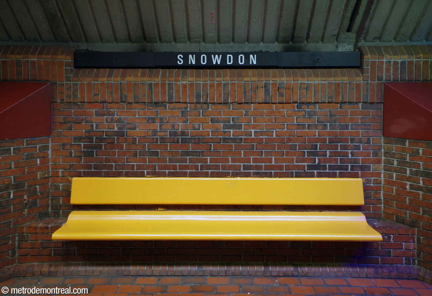 One of the platform benches on the upper level. The yellow benches are framed by pedestals topped by burgundy-coloured cornices and curved lampposts.