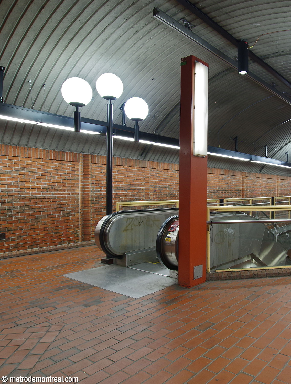 The upper level of the central vault is lit by lampposts at the corners of the stairwells, each holding three globe lamps, as well as by interesting supports with vertical light panels. Strip light fixtures were added to each side of the central vault in 2024-25.