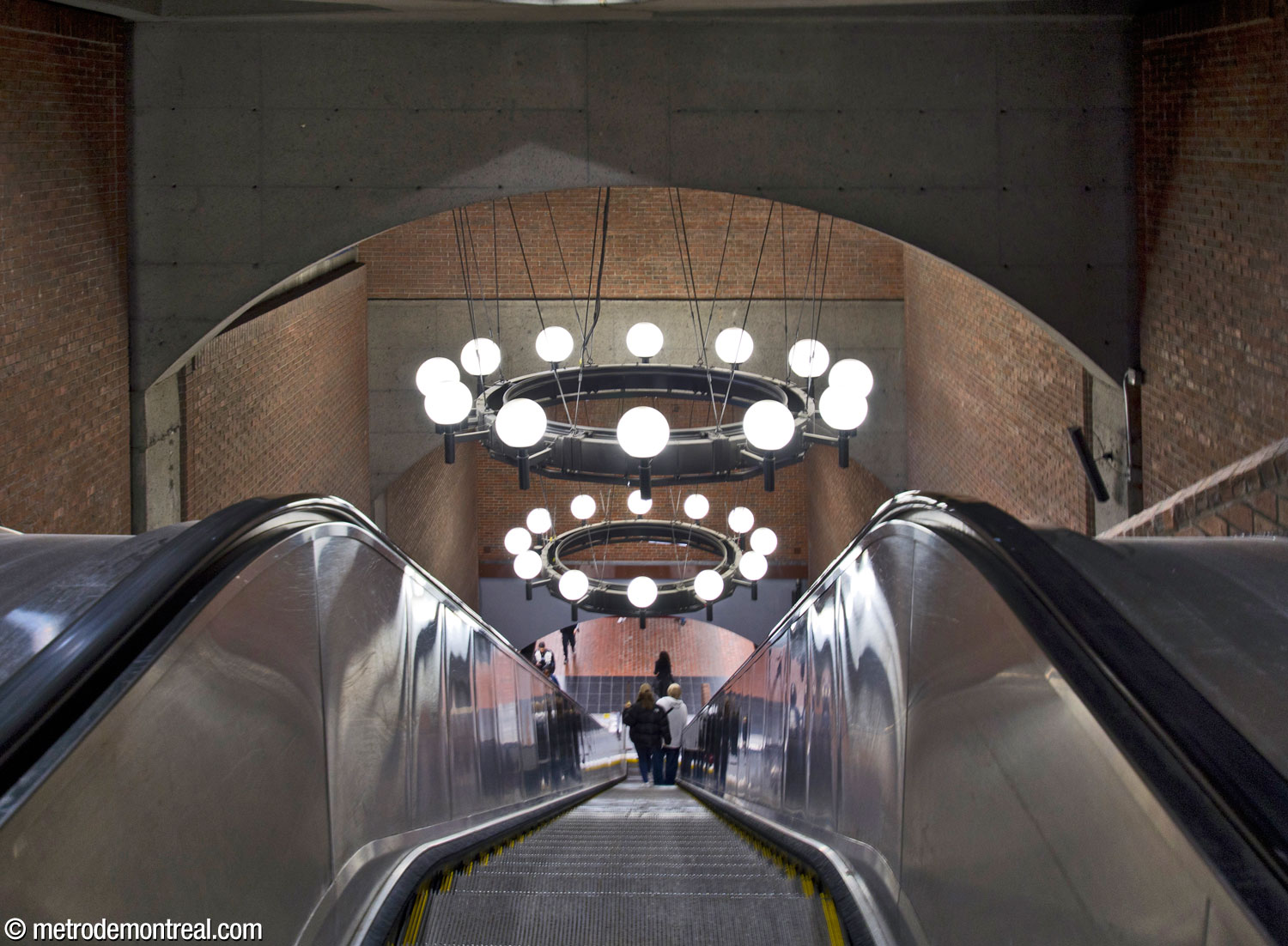 The dramatic escalator well connecting the ticket hall to the platforms, with its two huge chandeliers.
