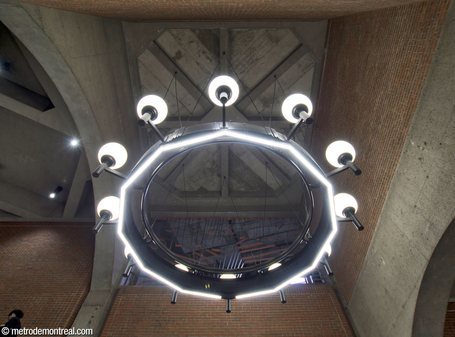 View from below of one of the chandeliers in the escalator well, with the sculptural grille by Jean-Louis Beaulieu behind.
