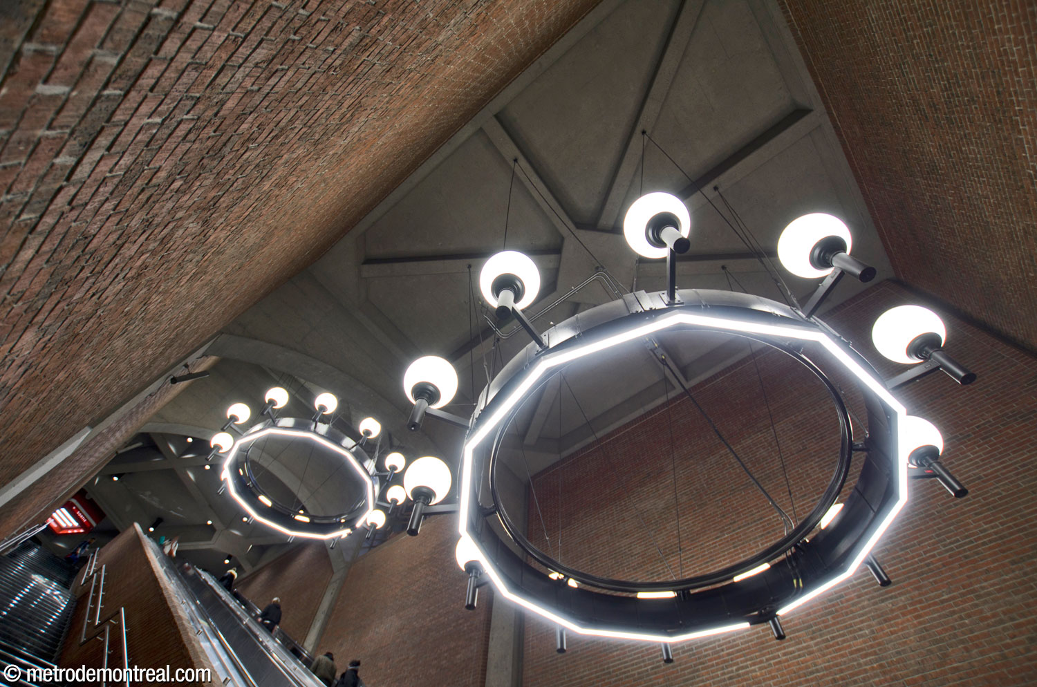 The escalator well and its two chandeliers seen from below. Strip light fixtures were added to the underside of the chandeliers in 2024-25 to increase the ambient light.