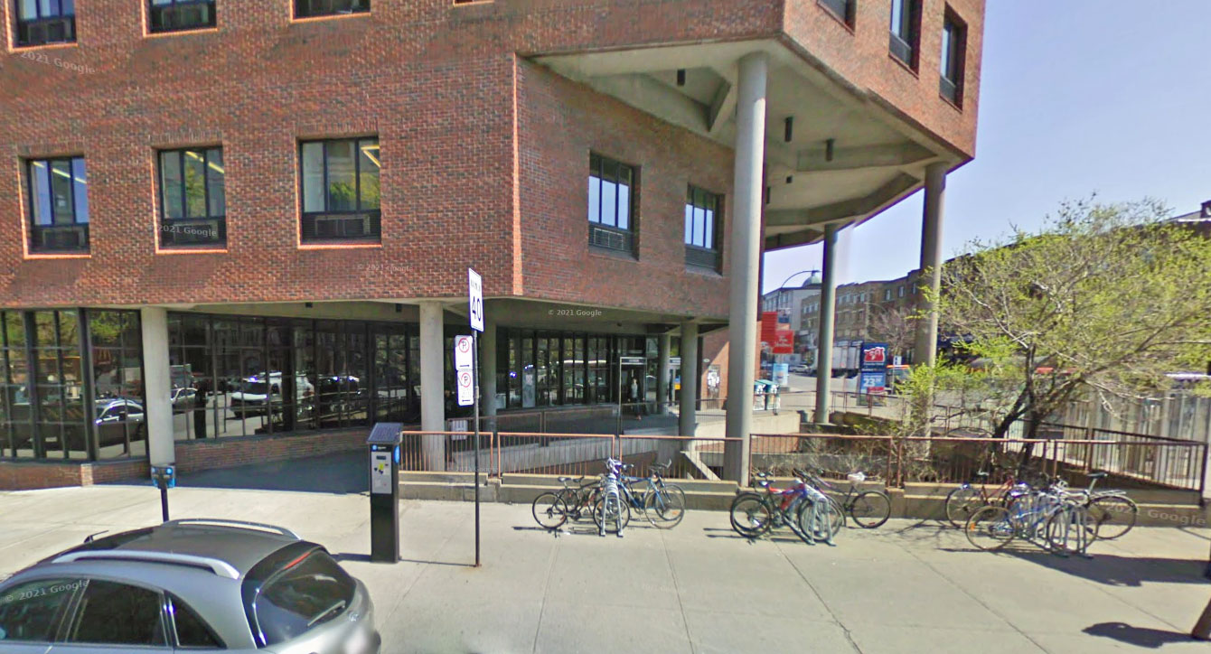 The station entrance seen in 2009, prior to the 2013-2016 renovations. The entrance opened onto an exterior walkway above the sunken garden. The renovations enclosed part of the walkway, with doors on either end.