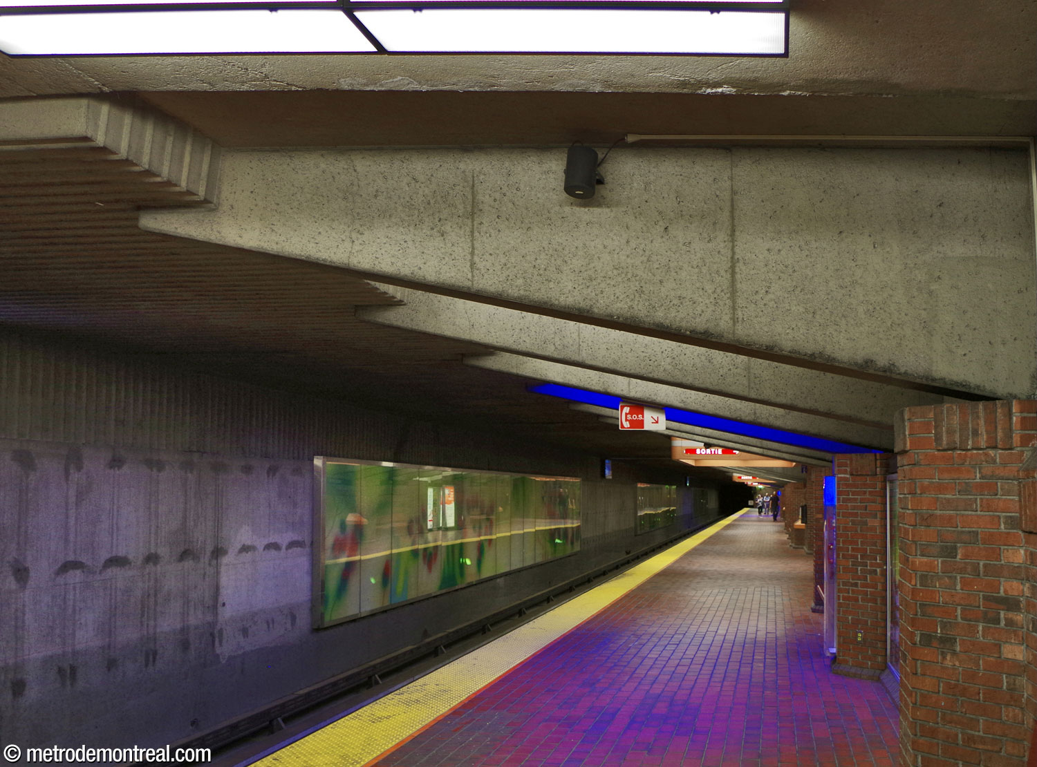 One of the lower platforms (the Montmorency platform on the orange line). Sections of the 'spring' mural from Les quatre saisons by Claude Guité line the tracks.