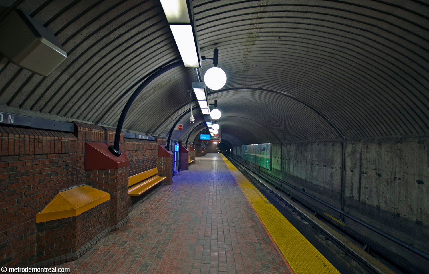 One of the upper platforms (the Côte-Vertu platform on the orange line), showing the vaulted ceiling emphasized by curved lampposts.
