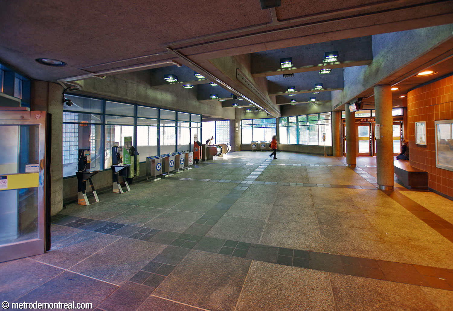The interior of the east headhouse. The Boulevard Saint-Michel exit is at right, the Boulevard Shaughnessy exit is at far left. The windows at left overlook the ticket hall and main volume below, with the stairs to the ticket hall at centre-left.