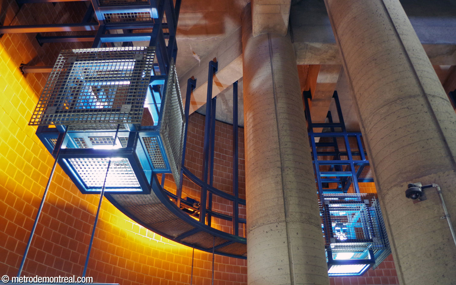Detail of the remarkable cube-shaped light fixture housings along the contour of the central volume ceiling. Their shapes suggest Japanese lanterns, with a postmodern industrial air provided by the metal armatures and grilles. The rails between the fixtures, as well as serving an aesthetic function, also serve as a catwalk for ease of maintenance.