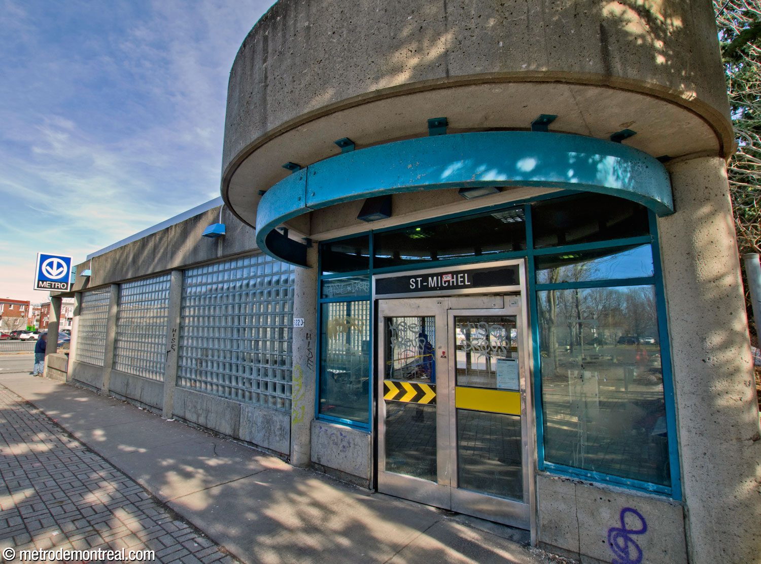 The northern entrance of the west headhouse, set back from the street and topped with a semicircular concrete awning.