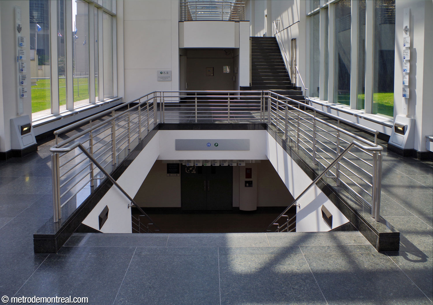 Un escalier à l'intérieur de l'atrium de la Maison OACI, se dirige vers le métro.