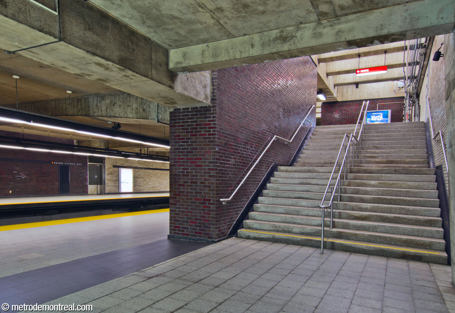 L'escalier est entre le quai Côte-Vertu et la mezzanine est séparé du quai par un mur de brique glacée marron pourpre.