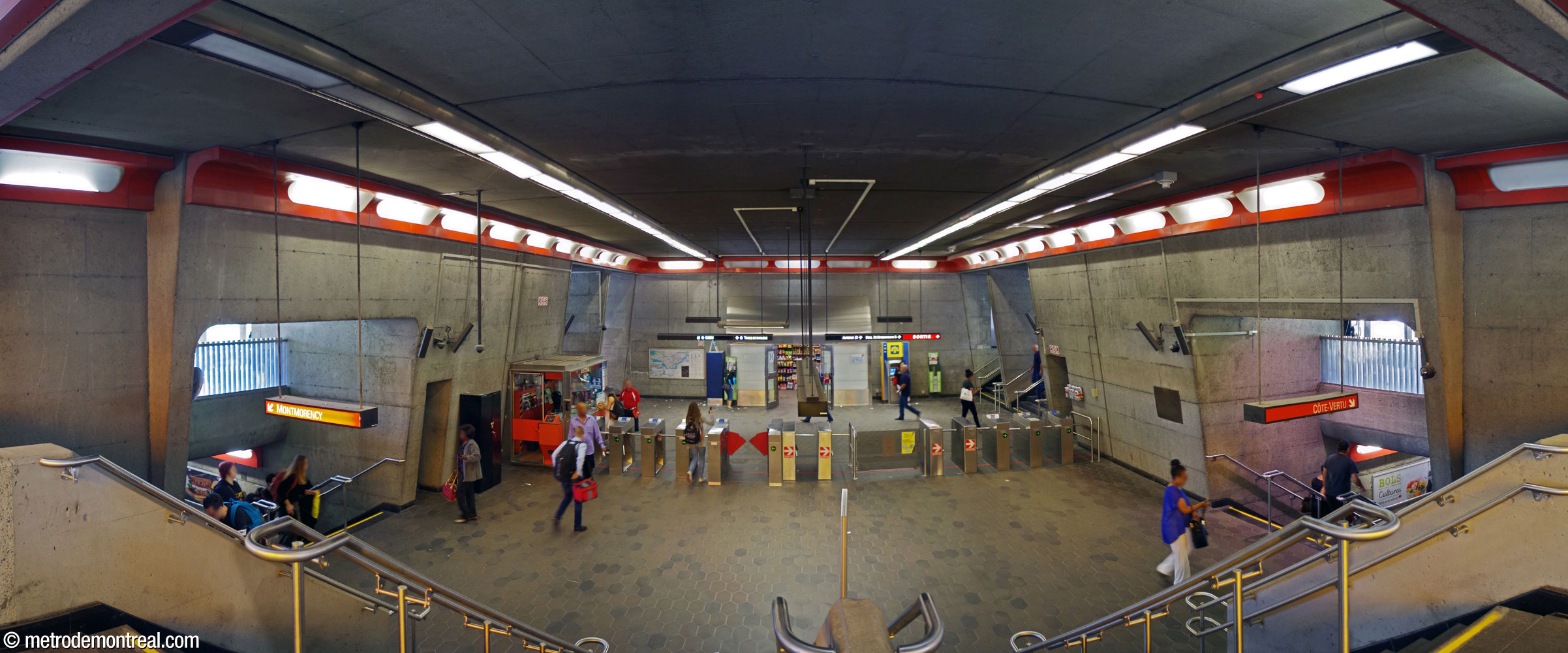 The station's main ticket hall, seen from the bridge between the two street-level side hallways. Outside the gateline, access to the commuter train station is at left and access from the street level is at right.