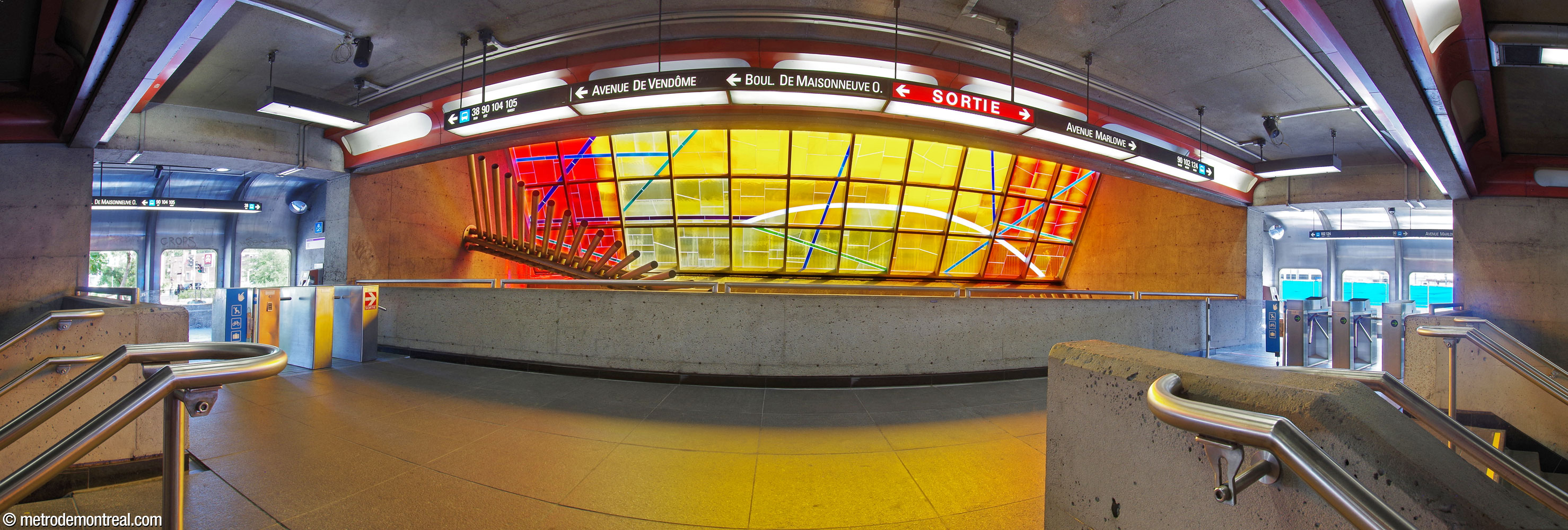The bridge between the two street-level side hallways of the original headhouse. During the first phase of renovations connected to the construction of the MUHC, it was integrated into the ticket hall’s fare-paid zone with a stairway (behind the viewer) to provide additional exits. The turnstiles on the north side are exit-only. The bridge faces Marcelle Ferron's stained glass window and sculpture.