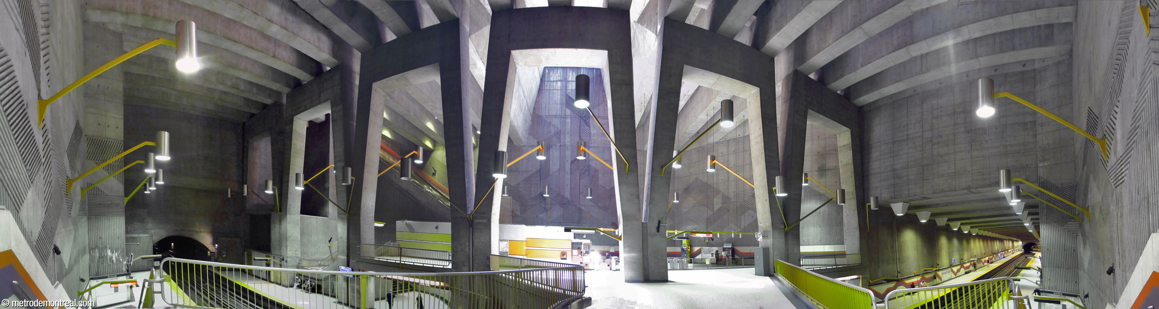 Looking back at the mezzanine from the end of the crossover, showing the light fixtures, the angled shape of the crossover, the skylight and the bas-reliefs by Antoine D. Lamarche and Claude Théberge on the high wall of the ticket hall.