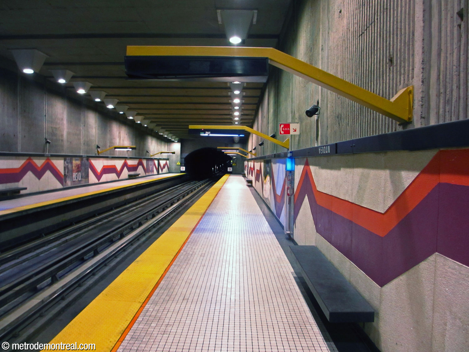 View of the Angrignon platform, showing the mural, sign/lamp holder, and benches.