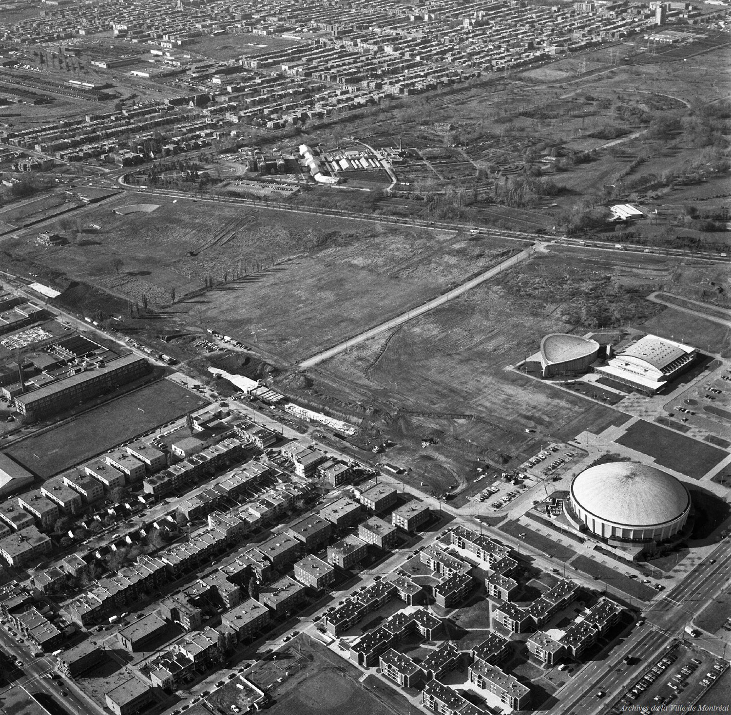 Aerial view of the station under construction in October 1972, showing the station and the tunnel to Pie-IX being built cut-and-cover in the thus far undeveloped Olympic Park site.