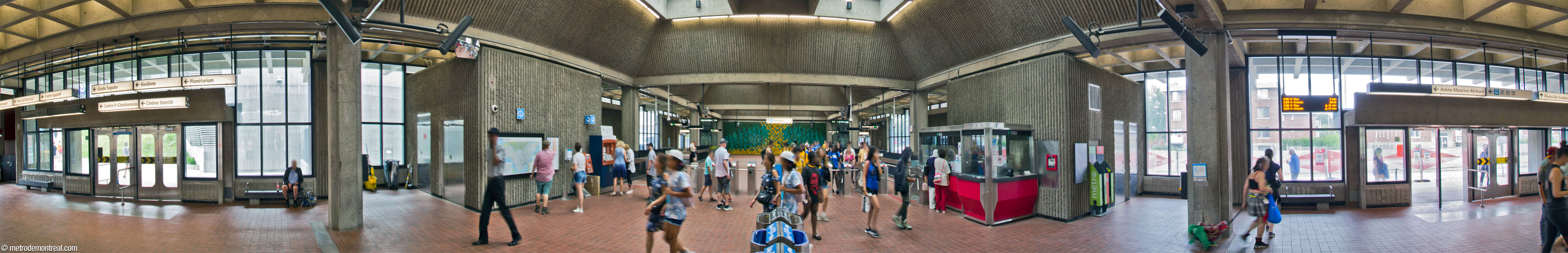Panorama of the interior of the headhouse, from the western fare-free zone. The north exit (left) gives access to the Olympic Park and the south (right) opens onto Avenue Pierre-De Coubertin. The outside walls are lined with extensive windows, admitting abundant sunlight.