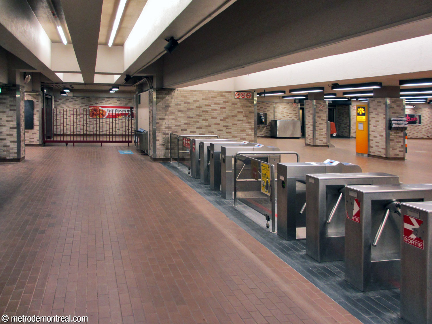 The west fare-paid zone, looking north. A grille separates the fare-paid zone from the adjacent hallway toward the Westmount Square tunnel.
