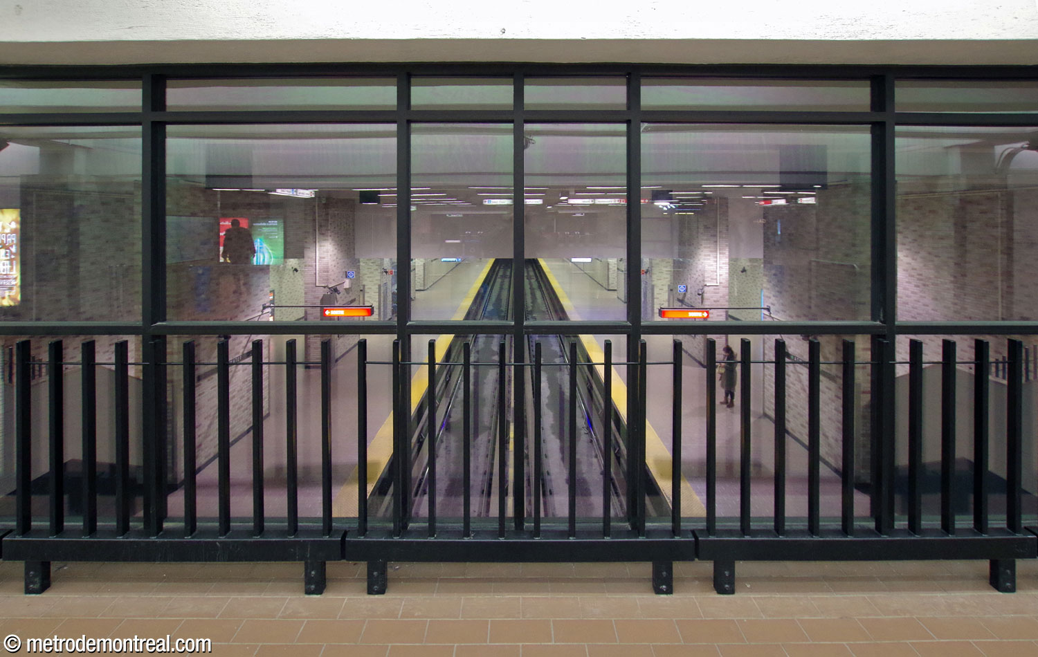 The overlooks from the fare-paid zones onto the platforms are now enclosed with glass for fire safety.