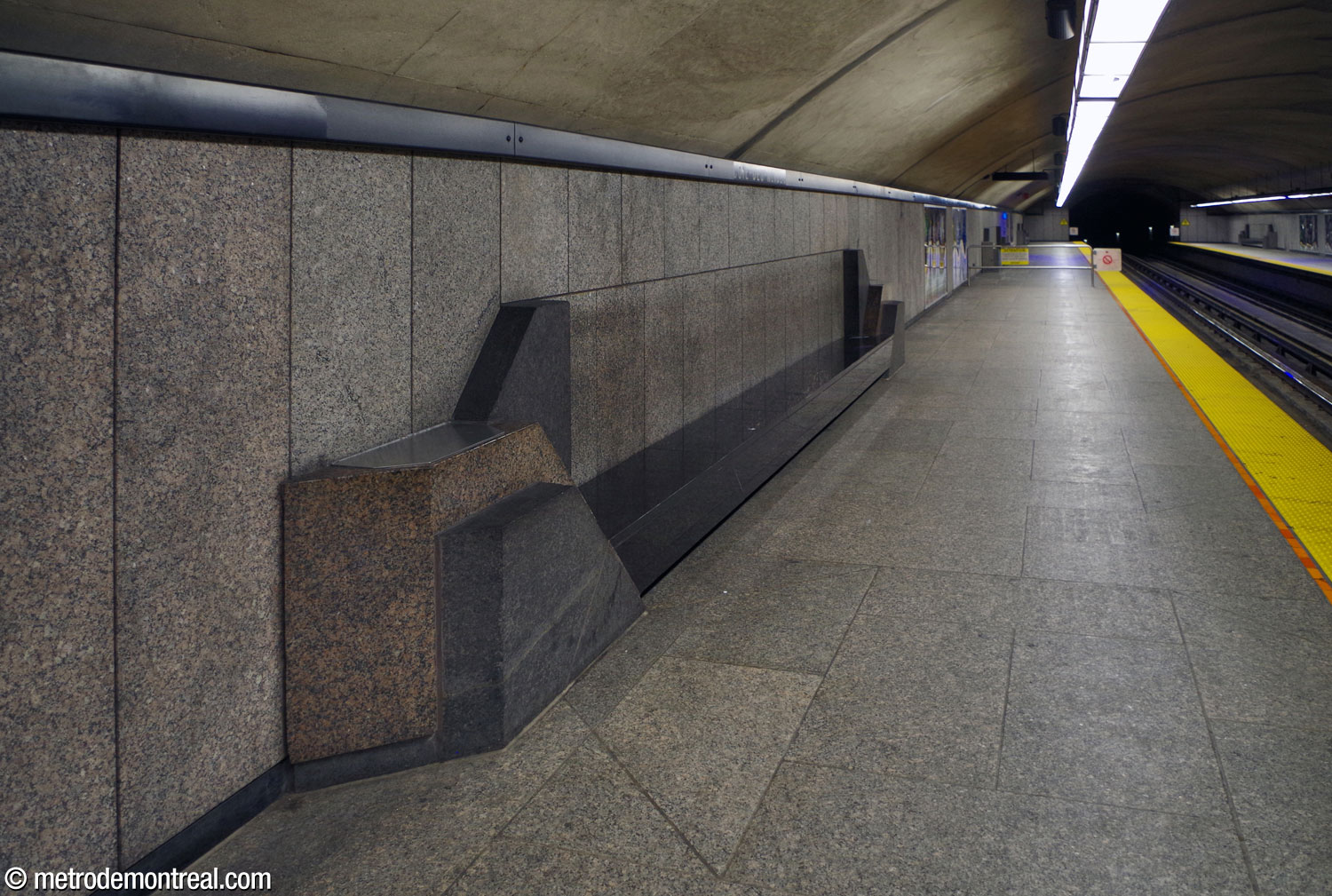 One of the station's impressive grey, black, and brown-grey granite platform benches. The angular forms recall Art Deco designs.