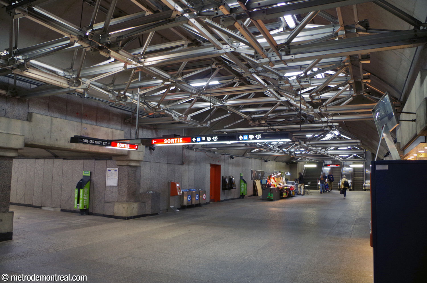 View south along the ticket hall tunnel toward the west access (right) and the perpendicular tunnel branching off toward the east access (left). Note the columns and lintel framing the entrance to the tunnel, repeating the shapes of the west headhouse.