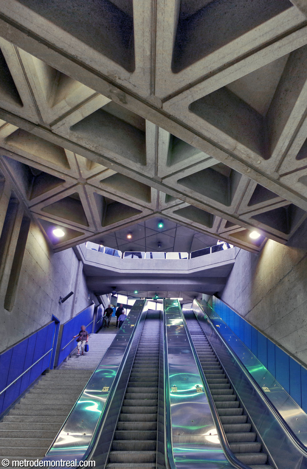 The ceiling above the escalator well in the east access is divided into oblique steps following the angle of the triangular ceiling coffers. The same angle is visible at the ends of the bridge that overlooks the well from the headhouse above.