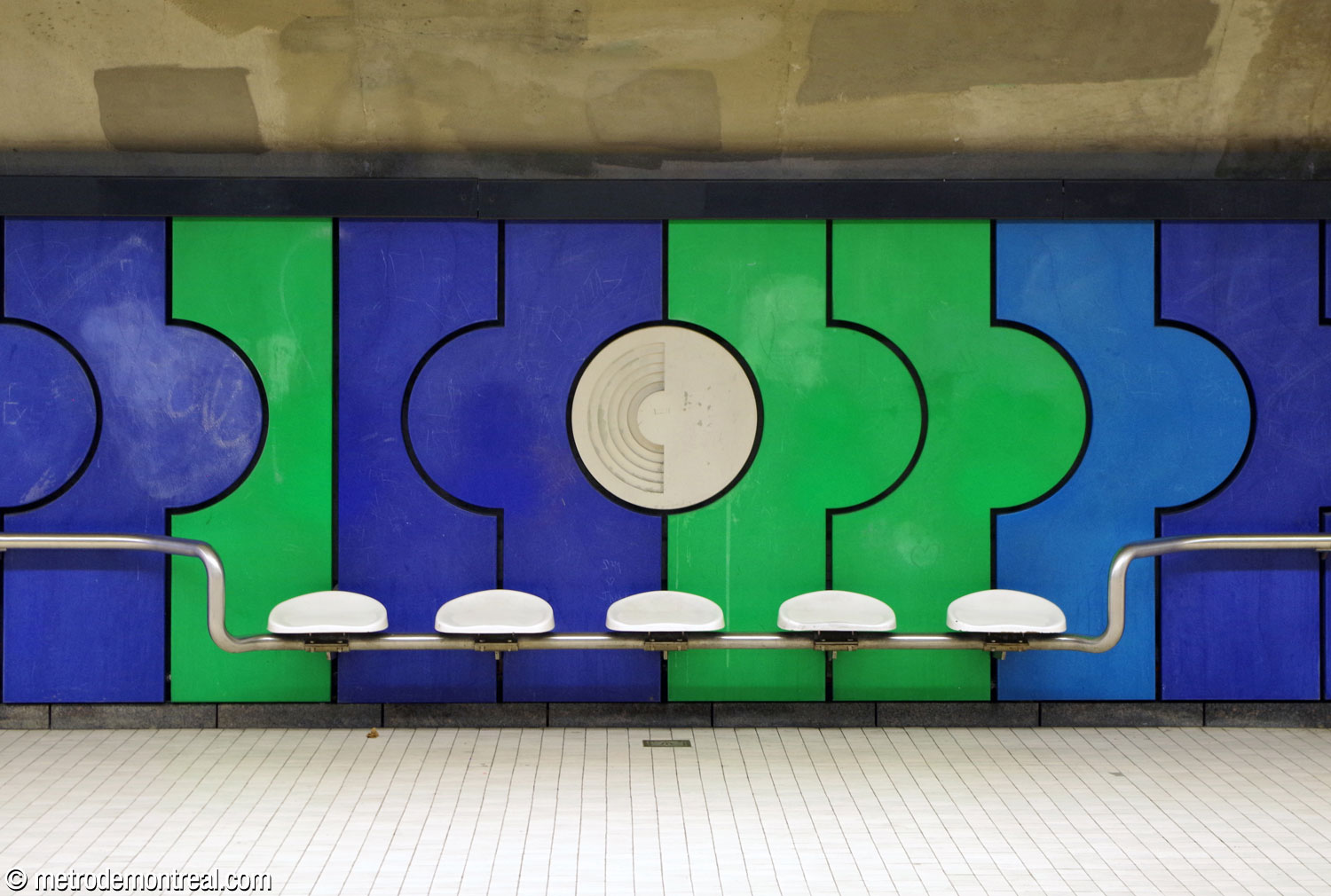 The steel rail that runs along the platform walls incorporates seating, consisting of individual white plastic seats.