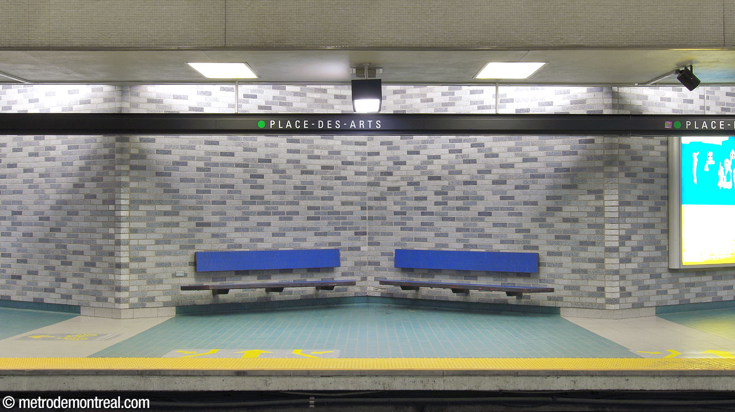 The station's benches, here set in one of the zigzags of the platform walls, are clad in bright blue tiles.