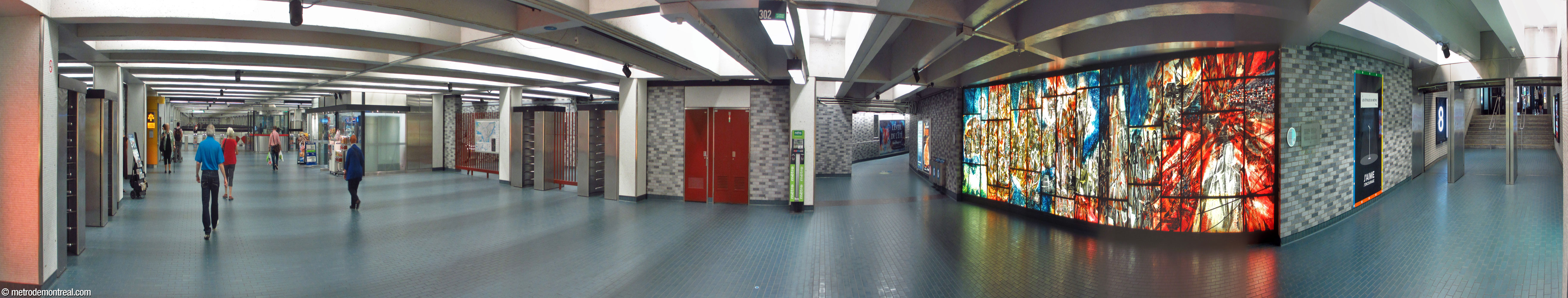 Panorama of the station's main concourse, leading to the eastern ticket hall (left). On the far left and centre left, the turnstile doors of the exit-only platform stairs. The corridor to the UQAM access is to the left of Frédéric Back's artwork, and the connection to the Place des Arts complex is to the right.