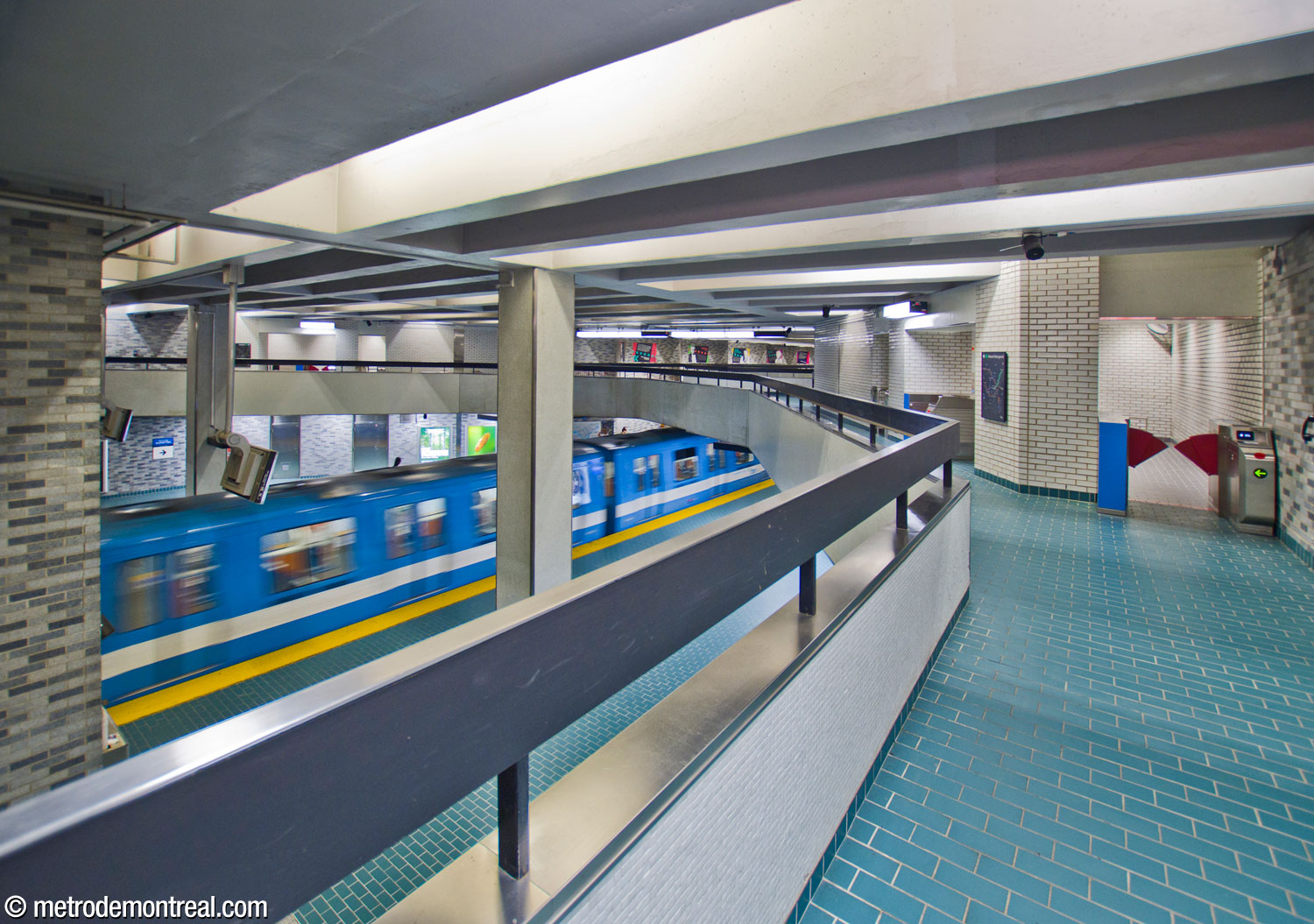 View of the western volume of the trainroom from the walkway above. This end of the walkways leads to the elevators to the platform, each with their own gateline (right).