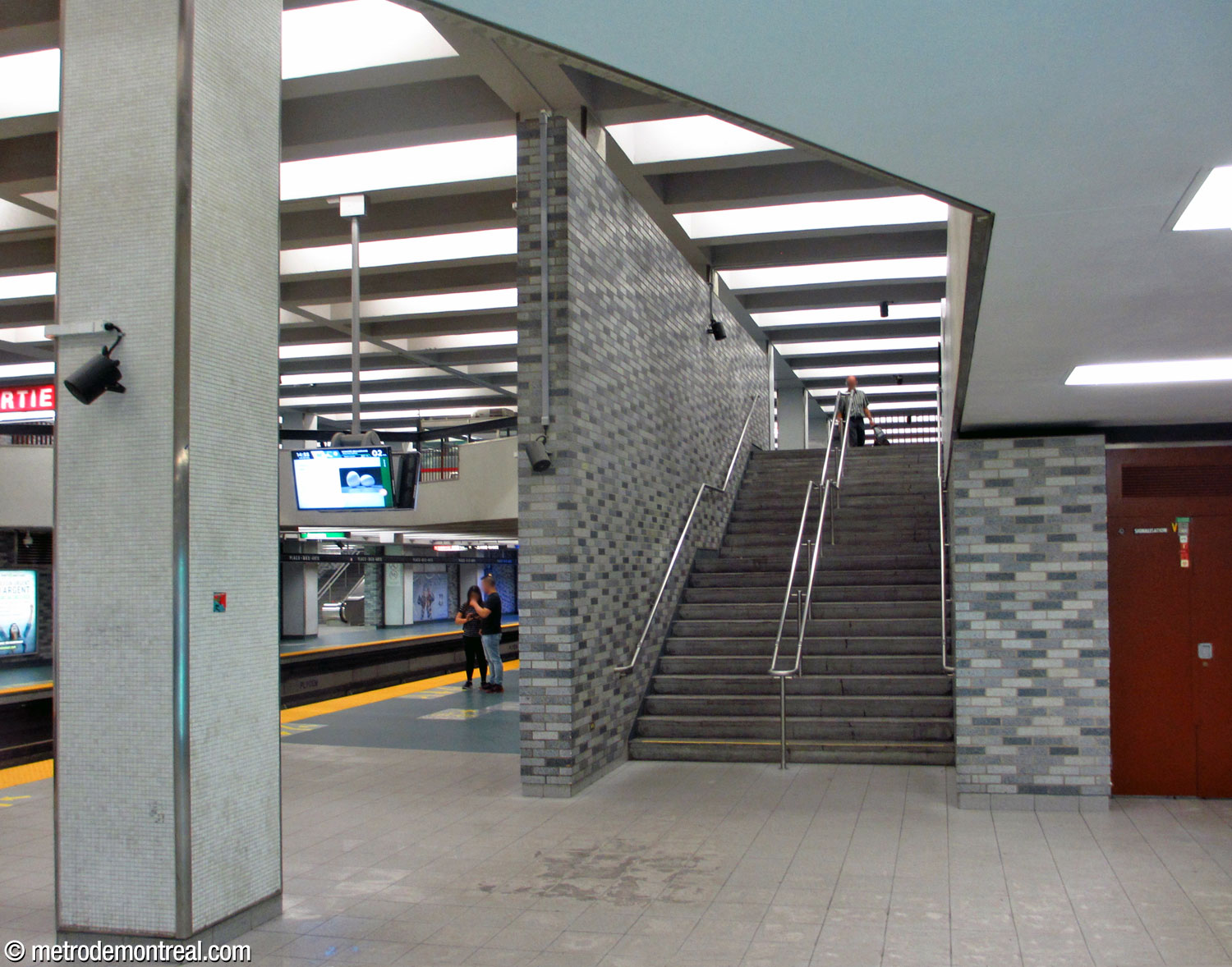 Stairs connecting the Honoré-Beaugrand platform to the east ticket hall, separated from the platform by a screen wall.